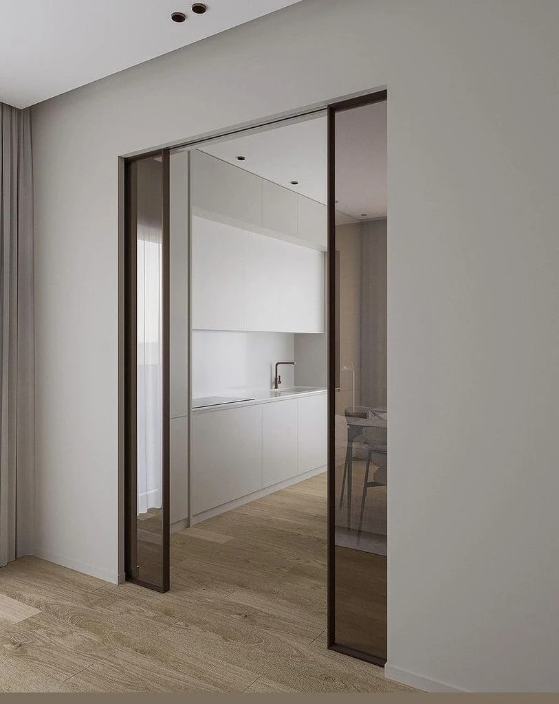 Modern double glass pocket doors sliding into the wall between interior spaces