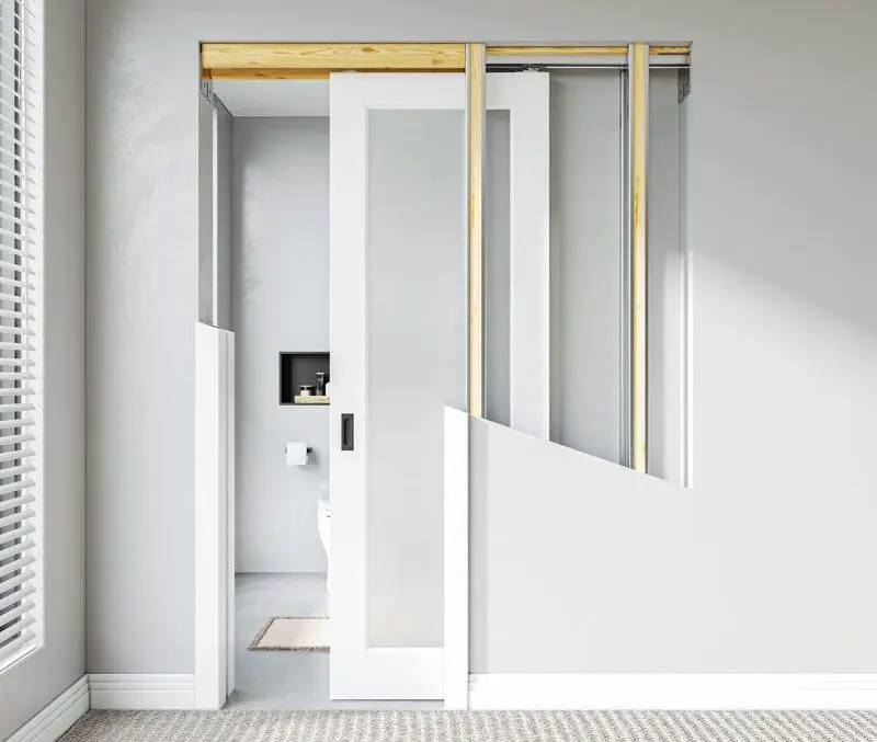 Pocket door frame installation with sliding door track inside an unfinished wall